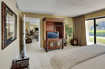 a bedroom with a bed and a flat screen tv at Edgewater Villa #502 in Panama City Beach