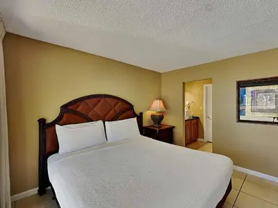 a bedroom with a large bed with white sheets at Edgewater Villa #502 in Panama City Beach