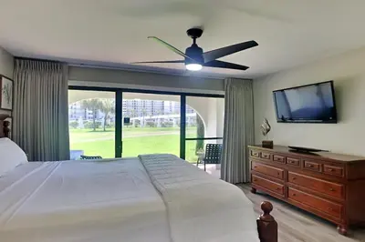 a bedroom with a large bed and a ceiling fan at Edgewater Villa #505 in Panama City Beach