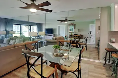 a dining room and living room with a table and chairs at Edgewater Villa #505 in Panama City Beach