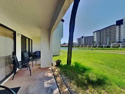 a porch with two benches and a field of grass at Edgewater Villa #505 in Panama City Beach