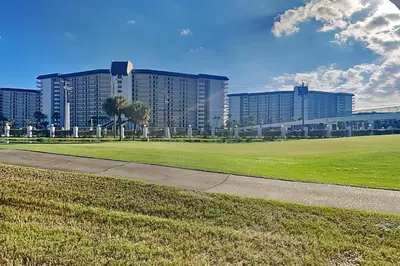 a view of a large building with a green field at Edgewater Villa #506 in Panama City Beach