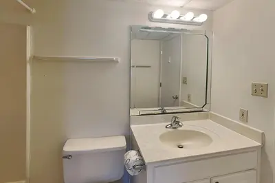 a bathroom with a sink and a toilet and a mirror at Edgewater Villa #506 in Panama City Beach
