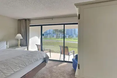 a bedroom with a bed and a sliding glass door at Edgewater Villa #506 in Panama City Beach