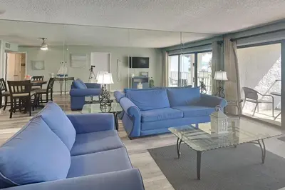 a living room with blue couches and a table at Edgewater Villa #512 in Panama City Beach