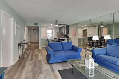 a living room with blue couches and a table at Edgewater Villa #512 in Panama City Beach