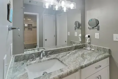 a bathroom with a sink and a large mirror at Edgewater Villa #512 in Panama City Beach