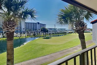a view of a golf course with palm trees at Edgewater Villa #512 in Panama City Beach