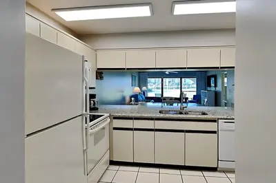 a kitchen with white cabinets and a sink at Edgewater Villa #602 in Panama City Beach