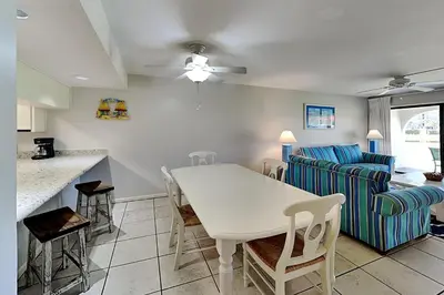 a kitchen and living room with a table and a couch at Edgewater Villa #602 in Panama City Beach