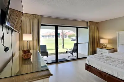 a bedroom with a bed and a view of a yard at Edgewater Villa #604 in Panama City Beach
