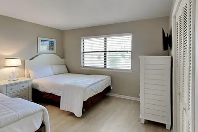a small bedroom with two beds and a window at Edgewater Villa #604 in Panama City Beach
