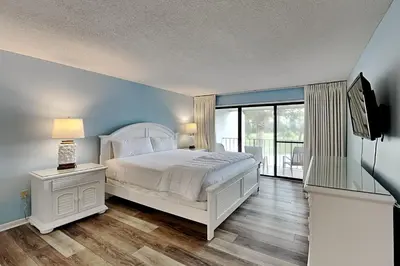 a bedroom with a white bed and a large window at Edgewater Villa #712 in Panama City Beach