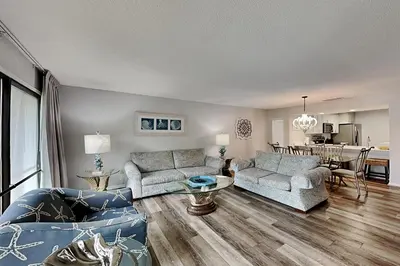 a living room with two couches and a table at Edgewater Villa #712 in Panama City Beach