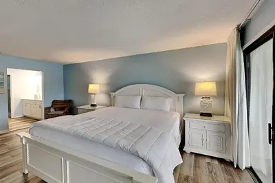 a bedroom with a large white bed and two night stands at Edgewater Villa #712 in Panama City Beach