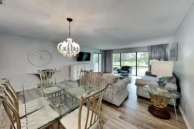 a dining room and living room with a glass table at Edgewater Villa #712 in Panama City Beach