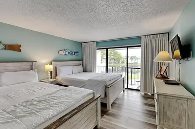 a bedroom with two beds and a balcony at Edgewater Villa #712 in Panama City Beach