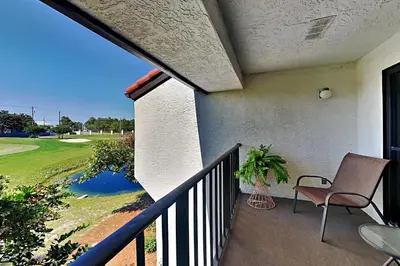 a balcony with a chair and a golf course at Edgewater Villa #2011 in Panama City Beach