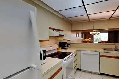 a kitchen with white cabinets and a stove top oven at Edgewater Villa #2011 in Panama City Beach
