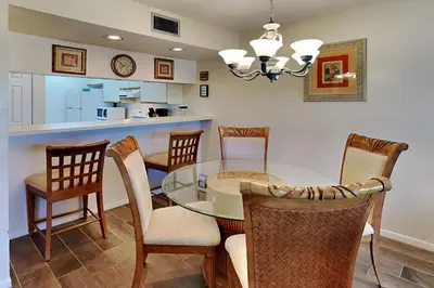 a kitchen and dining room with a glass table and chairs at Edgewater Villa #2011 in Panama City Beach