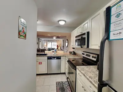 a large kitchen with white cabinets and appliances at Edgewater Villa #2209 in Panama City Beach