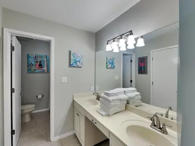 a bathroom with a sink and a toilet and a mirror at Edgewater Villa #2209 in Panama City Beach