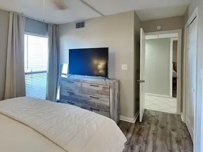 a bedroom with a bed and a flat screen tv at Edgewater Tower I #207 in Panama City Beach