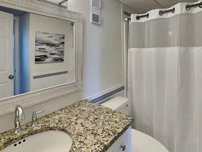 a bathroom with a sink and a mirror and a toilet at Edgewater Tower I #207 in Panama City Beach