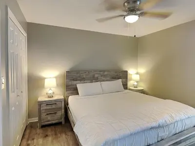 a bedroom with a bed and two night stands with lamps at Edgewater Tower I #207 in Panama City Beach
