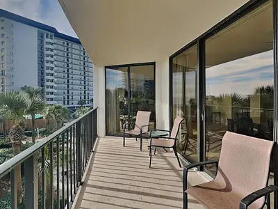 a balcony with chairs and tables on a building at Edgewater Tower I 211 in Panama City Beach