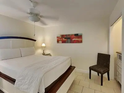a bedroom with a bed and a chair in it at Edgewater Tower I 211 in Panama City Beach