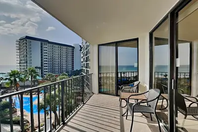 a balcony with chairs and a view of the ocean at Edgewater Tower I 406 in Panama City Beach