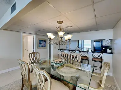 a dining room with a glass table and chairs at Edgewater Tower I 610 in Panama City Beach