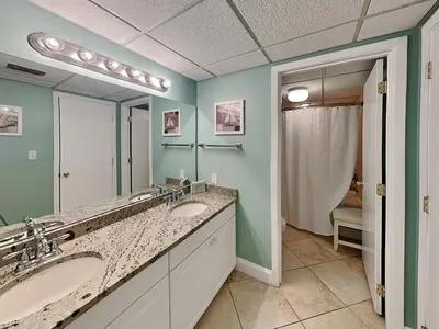 a bathroom with two sinks and a large mirror at Edgewater Tower I 802 in Panama City Beach