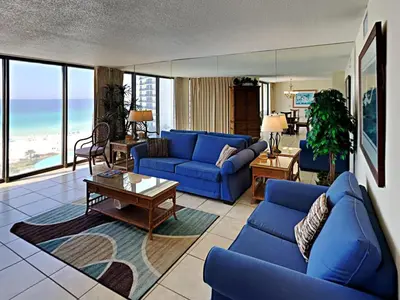 a living room with blue couches and the ocean at Edgewater Tower I 806 in Panama City Beach