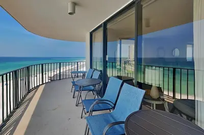 a balcony with chairs and tables and the ocean at Edgewater Tower II 912 in Panama City Beach
