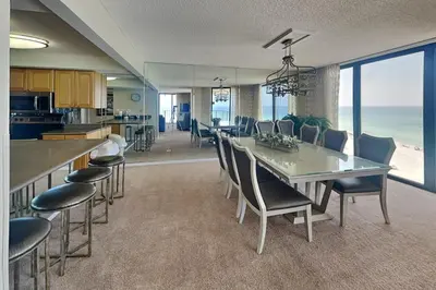 a kitchen and dining room with a table and chairs at Edgewater Tower II 912 in Panama City Beach