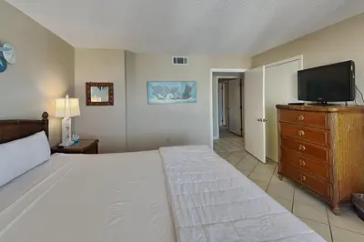 a bedroom with a bed and a flat screen tv at Edgewater Tower II 912 in Panama City Beach