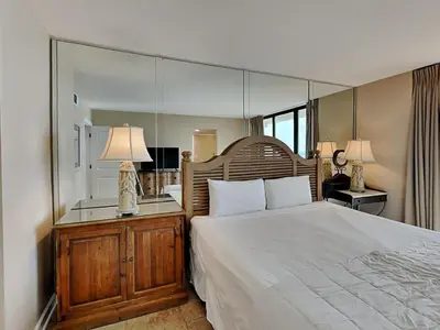 a bedroom with a large bed with a large mirror at Edgewater Tower II 1001 in Panama City Beach