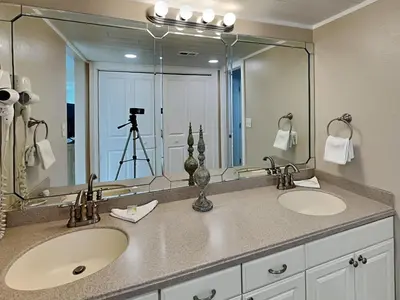 a bathroom with two sinks and a large mirror at Edgewater Tower II 1001 in Panama City Beach
