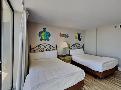 a bedroom with two beds with white sheets at Edgewater Tower III 114 in Panama City Beach