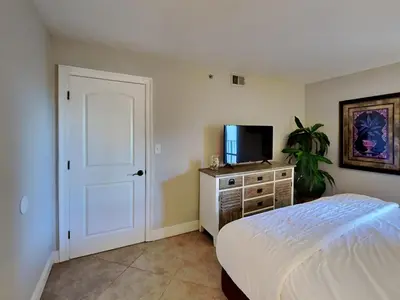 a bedroom with a bed and a flat screen tv at Edgewater Tower III 114 in Panama City Beach