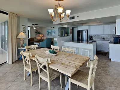 a kitchen and dining room with a wooden table and chairs at Edgewater Tower III 114 in Panama City Beach