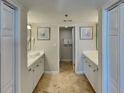 a bathroom with two sinks and two mirrors at Edgewater Tower III #501 in Panama City Beach