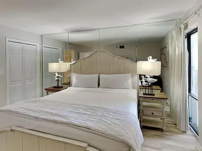 a bedroom with a large white bed and two lamps at Edgewater Tower III #501 in Panama City Beach