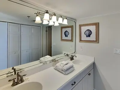 a bathroom with two sinks and a large mirror at Edgewater Tower III #501 in Panama City Beach
