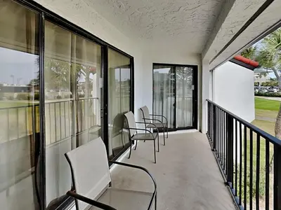a row of chairs on a balcony with windows at Edgewater Villa 1216 in Panama City Beach