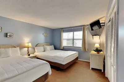 a bedroom with two beds and a television in it at Edgewater Villa 1501 in Panama City Beach