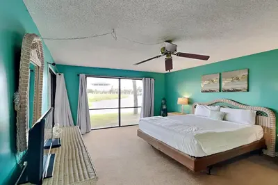 a bedroom with a bed and a ceiling fan at Edgewater Villa 1501 in Panama City Beach