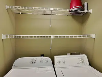a laundry room with a washing machine and a drying rack at Edgewater Villa 1501 in Panama City Beach